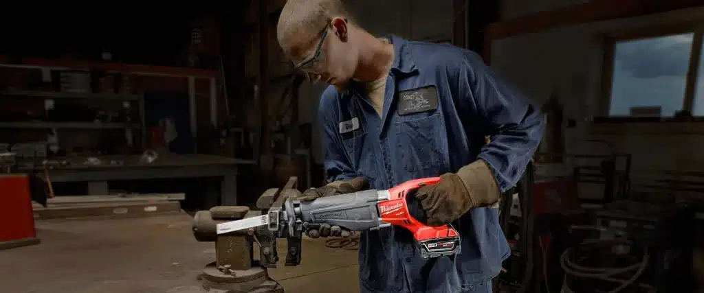 Technician using one of Milwaukee fuel powered tools to cut through metal 